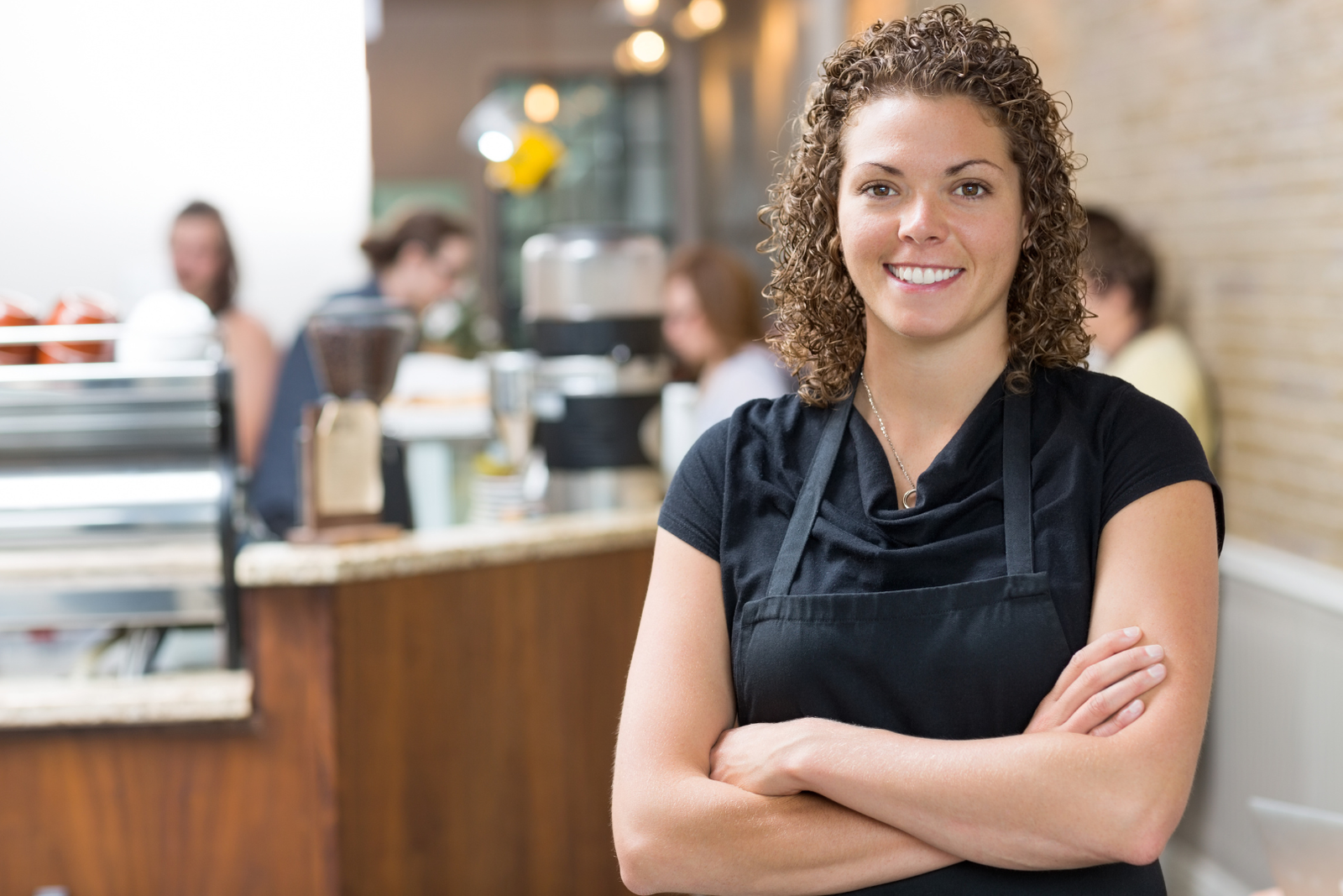 Business Woman ih her cafe with arms crossed looking at the camera