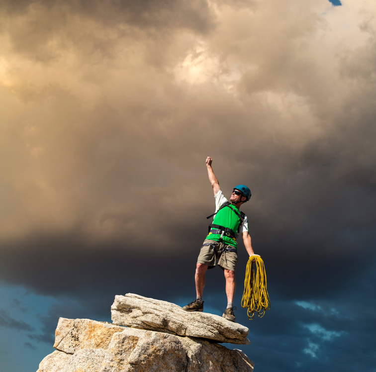 Man on top of rocks with his arm up