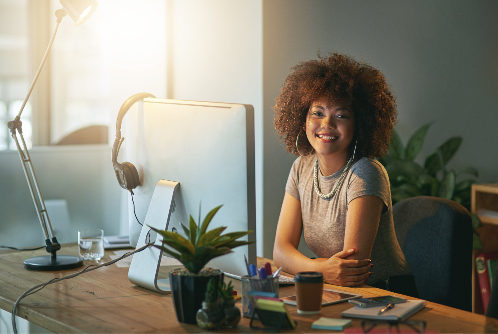 Woman using her computer at home, smiling while looking directly at the viewer